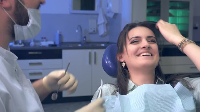 Dentist jokes with a patient during treatment, and the patient laughs