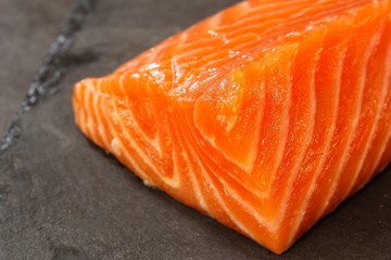 Fresh salmon fillet on slate background, selective focus