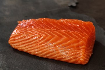 Fresh salmon fillet on slate background, selective focus