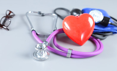 Red heart, stethoscope and medical equipmenton on white background