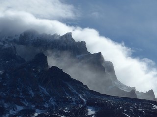 Clouds swirling around the peaks of large towers in the strong Patagonia winds in Torres del Paine National Park. 