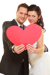Groom and bride couple holding heart