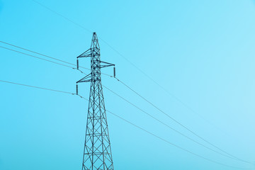 high voltage electricity post with cables and blue sky