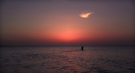 Amazing gorgeous beautiful view of warm dark inviting sunset time with people in background at Cuban Cayo Coco island 