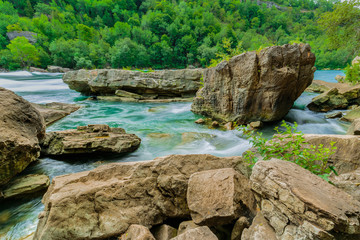 Beautiful amazing gorgeous natural landscape view of Niagara Falls river with big rock and stones against forest background 