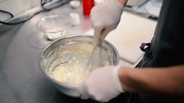 Man mixes raw eggs with the flour.
