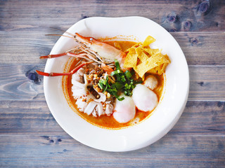 white bowl of Tom Yum Kung with noodles and seafood