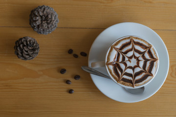 hot coffee with star chocolate whipped-cream and coffee bean on wooden table in coffee shop