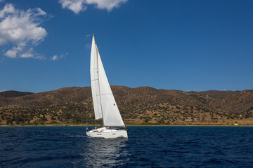 Naklejka na ściany i meble Ship yachts with white sails in the open Sea. Luxury sailing boats.