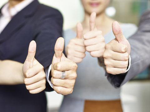 business people showing thumb-up signs