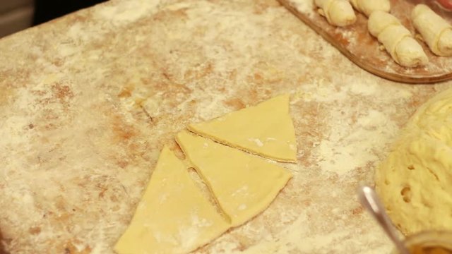 Woman working with dough. making homemade croissants