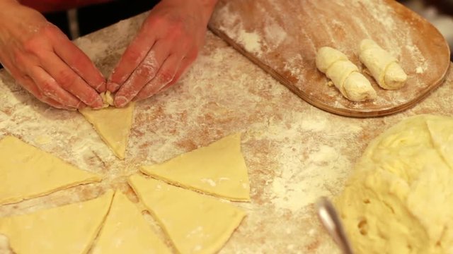 Woman working with dough. making homemade croissants