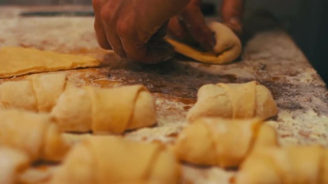 A woman puts on fresh pieces of dough apricot jam