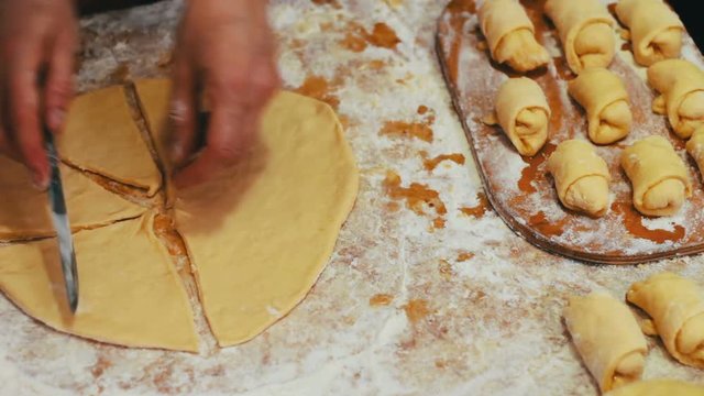 A woman puts on fresh pieces of dough apricot jam
