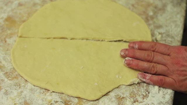 Woman cutting dough with a knife