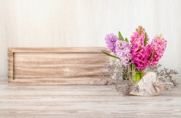 Spring arrangement with hyacinth flowers and wooden heart