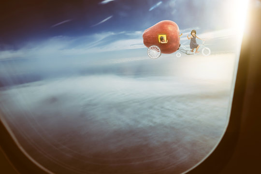 Happy sister enjoy with fantasy apple bike .,seen through window of an aircraft , dreams and travel concept .