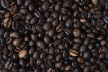 Background of coffee beans. A lot of coffee beans spilling on a table