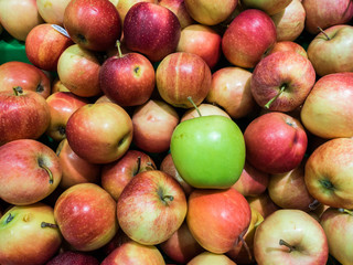 Green apple amongst Red Apples