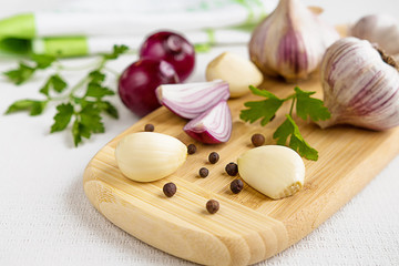 Obraz na płótnie Canvas Fresh garlic, onion and spices on a light background closeup