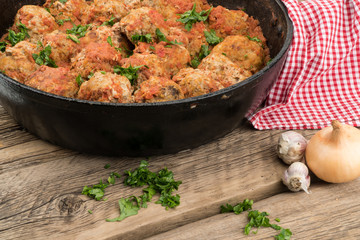 meat balls with herbs in pan on wooden rustic background.