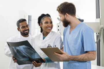 Medical Professionals With Chest X-ray And Clipboard In Hospital