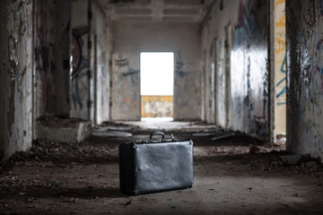 Suitcase in old abandoned ruin