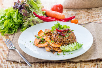 chinese cuisine, salt salmon fish and egg fried rice and vegetables with ingredients on rustic background.