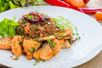 chinese cuisine, salt salmon fish and egg fried rice and vegetables with ingredients on rustic background.