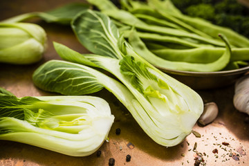 Fresh and raw Chinese cabbage pak choi and other green vegetables on vintage background. 