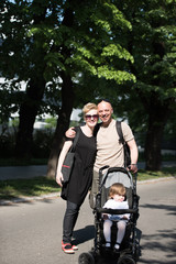 couple with baby pram in summer park