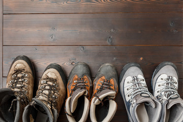 many hiking and trekking shoes for travel on wooden background