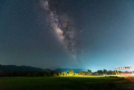 Milky way galaxy with stars and space dust in the Green Terraced Rice Field in Thailand