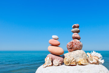 Concept of harmony and balance. double Rock Zen and shells on the background of summer sea