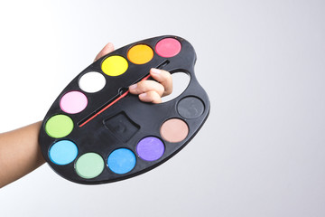 Painter hand holding water color plate