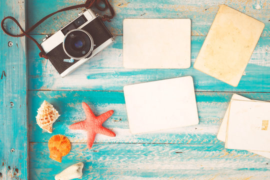 Top view composition - Blank paper photo frames with starfish, shells, coral and items on wooden table. Concept of remembrance and nostalgia in summer tourism, travel and vacation. vintage color tone.