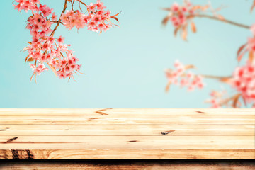 Naklejka na ściany i meble Top of wood table empty ready for your product and food display or montage with pink cherry blossom flower (sakura) on sky background in spring season. vintage color tone.