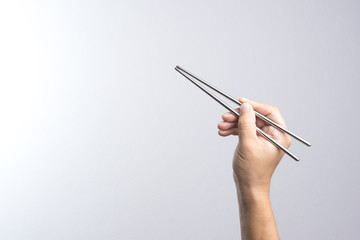 Hand holding stainless chop stick