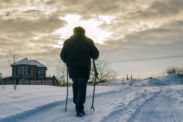 Film toned image with lonely wanderer on a snowy road