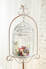 White vintage decorative bird cage with beautiful flowers