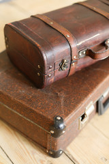 Brown vintage suitcases on the old wooden floor