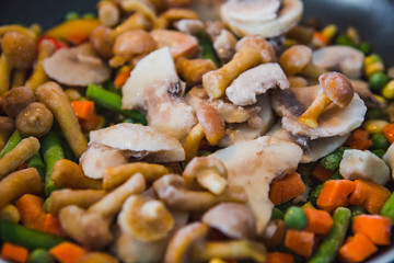 Frozen vegetables close-up: carrots, mushrooms, peas, corn, tomato.