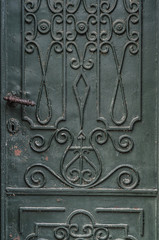 Green old metal door with ornaments