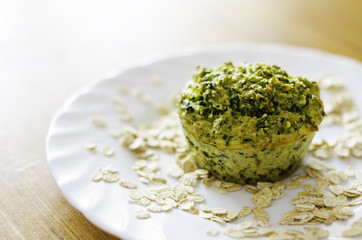 Spinach and oat flakes muffin on a white plate
