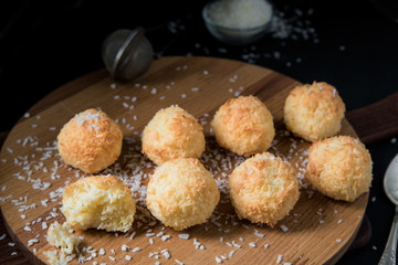 Crunchy coconut cookies Congolais on a wooden board against a dark background