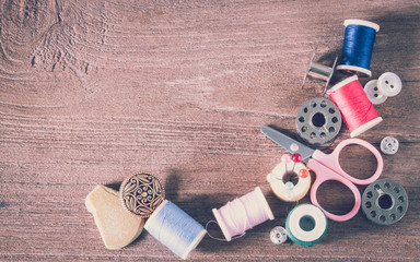 Sewing tools on a wooden background in vintage syle color
