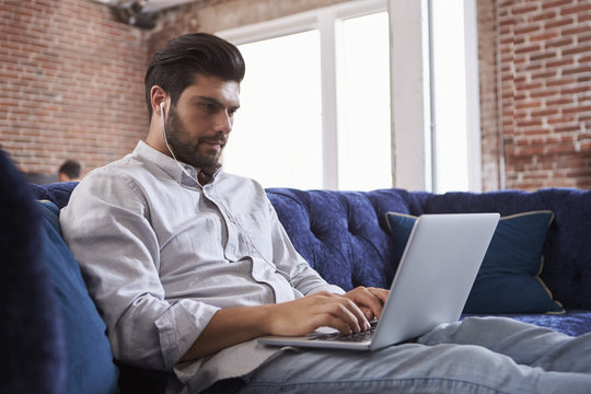 Businessman Working On Sofa In Modern Creative Office