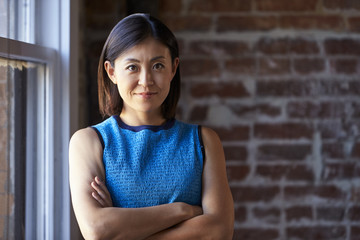 Portrait Of Businesswoman In Office Standing By Window