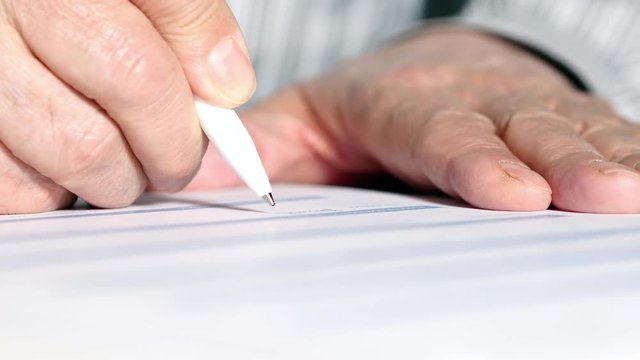 A Man Signs A Paper Document
