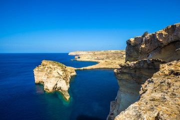 Gozo, Malta - Tha beautiful Fungus Rock on the Island of Gozo with the Azure window at background and clear blue sky